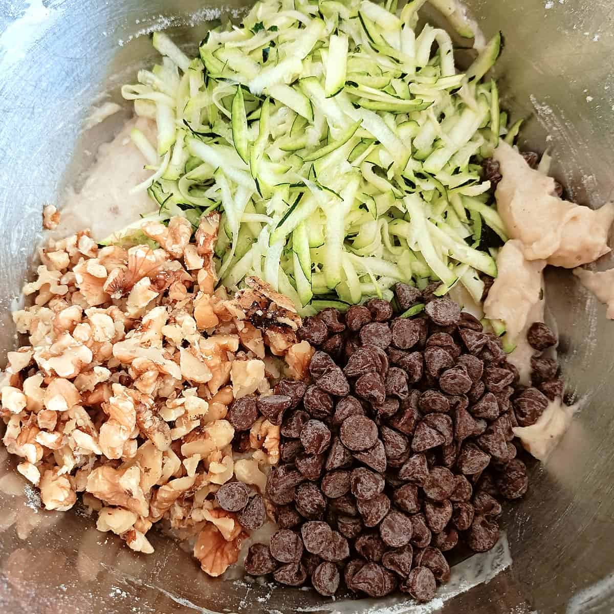 Add shredded zucchini. chocolate chips, and walnuts